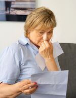 woman reading a paper and looking troubled