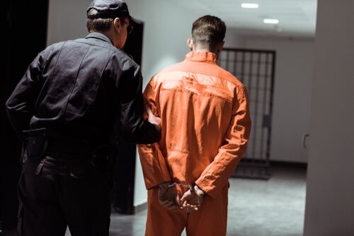 Inmate being taken to a jail cell.