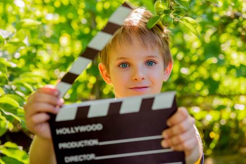 child holding a film slate