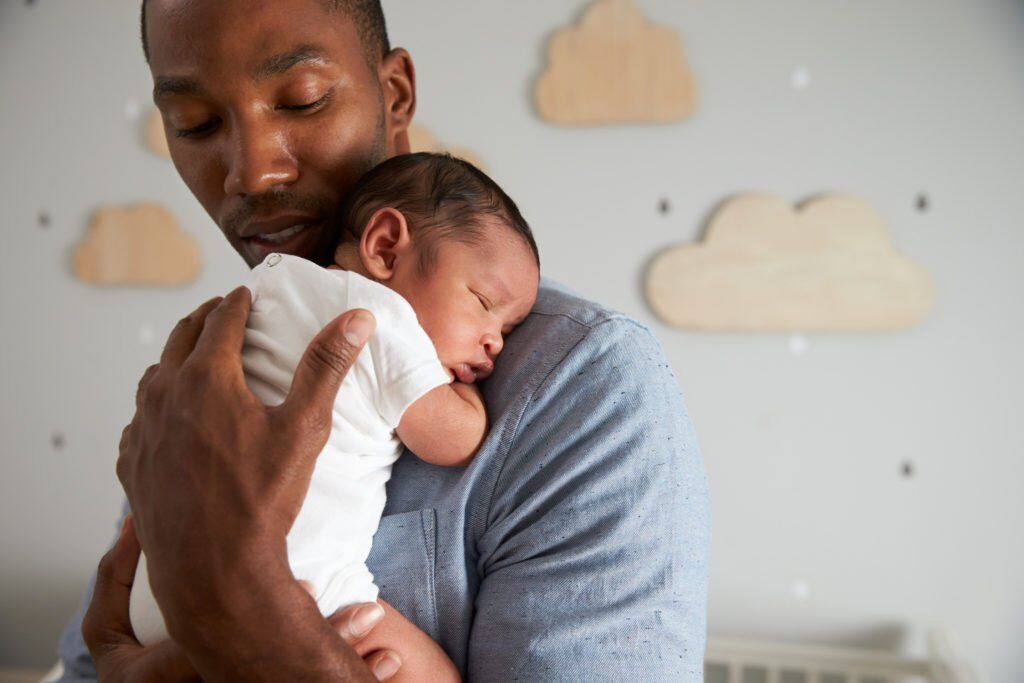 New father holding newborn during baby-bonding leave - California