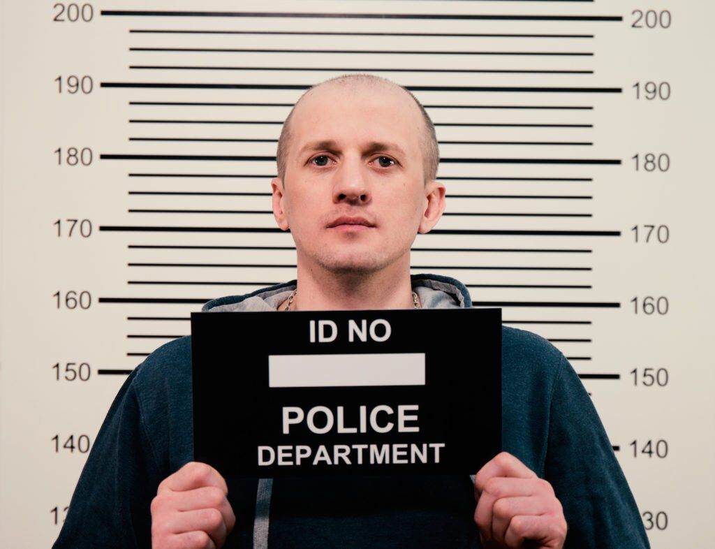 Mug shot of man holding up sign