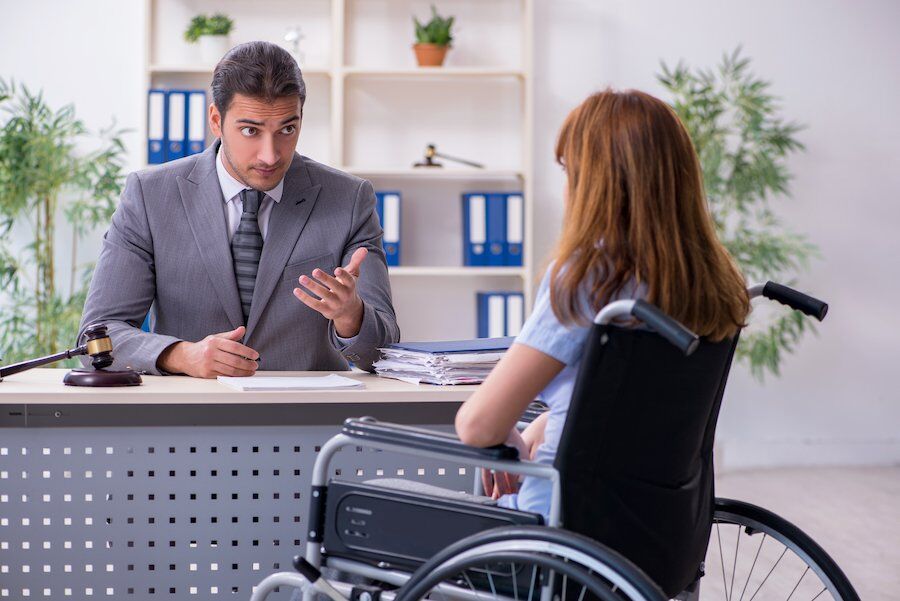 Injured worker in wheelchair discussing settlement