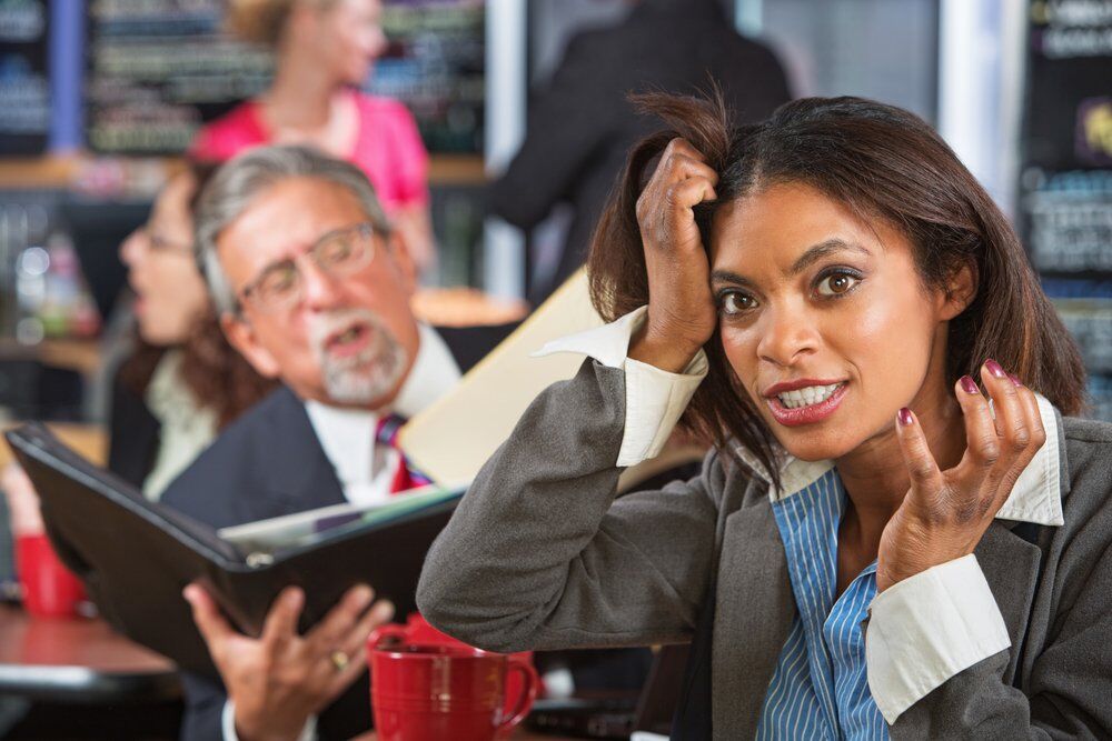 An employee pulling her hair in anger over her annoying boss.