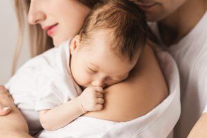 A mother and father holding their newborn